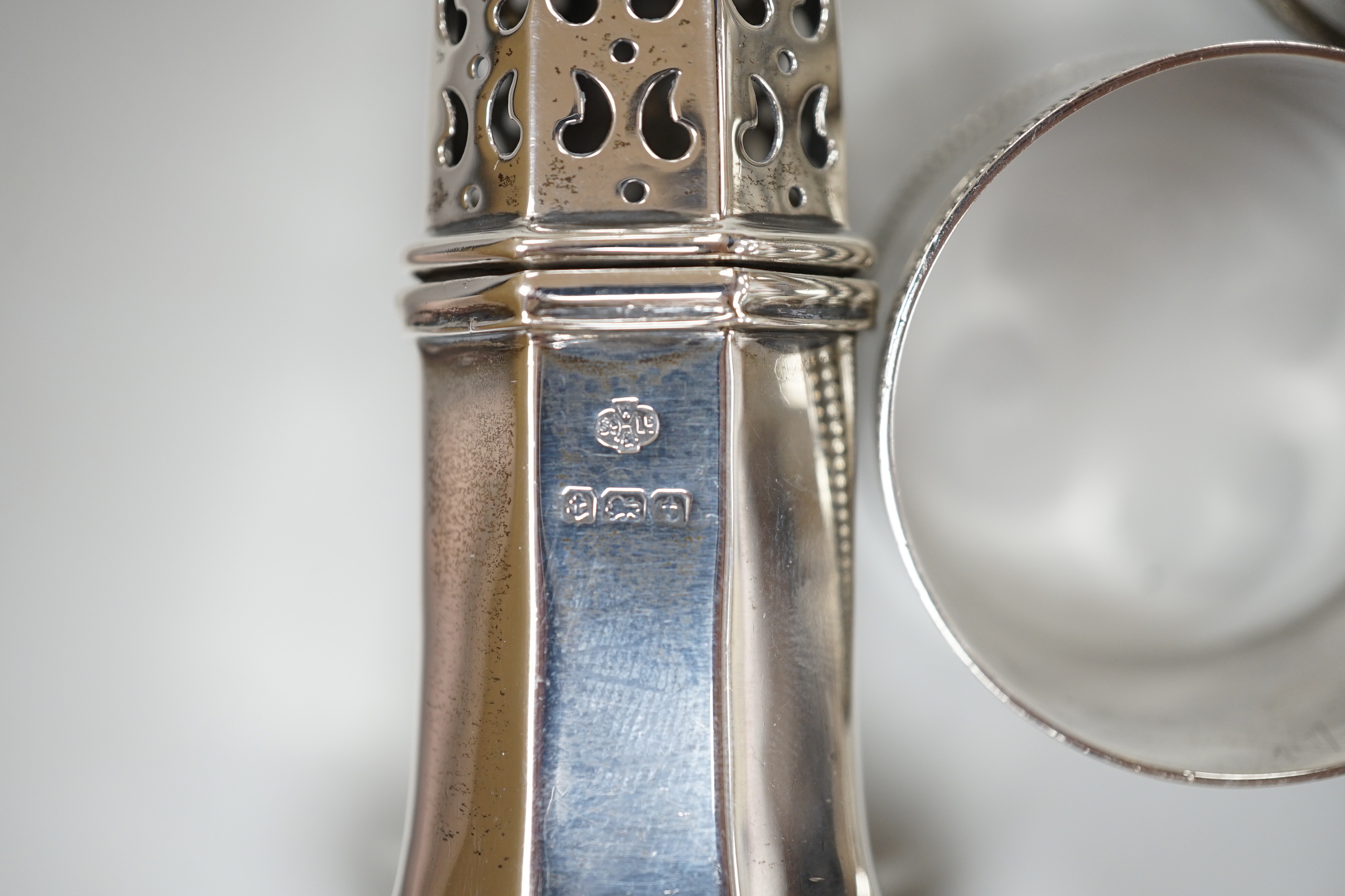 Sundry small silver including a George V pepperette, four silver napkin rings, a silver mounted implement stand, pair of salts (liner missing), four silver spoons and a George IV caddy spoon.